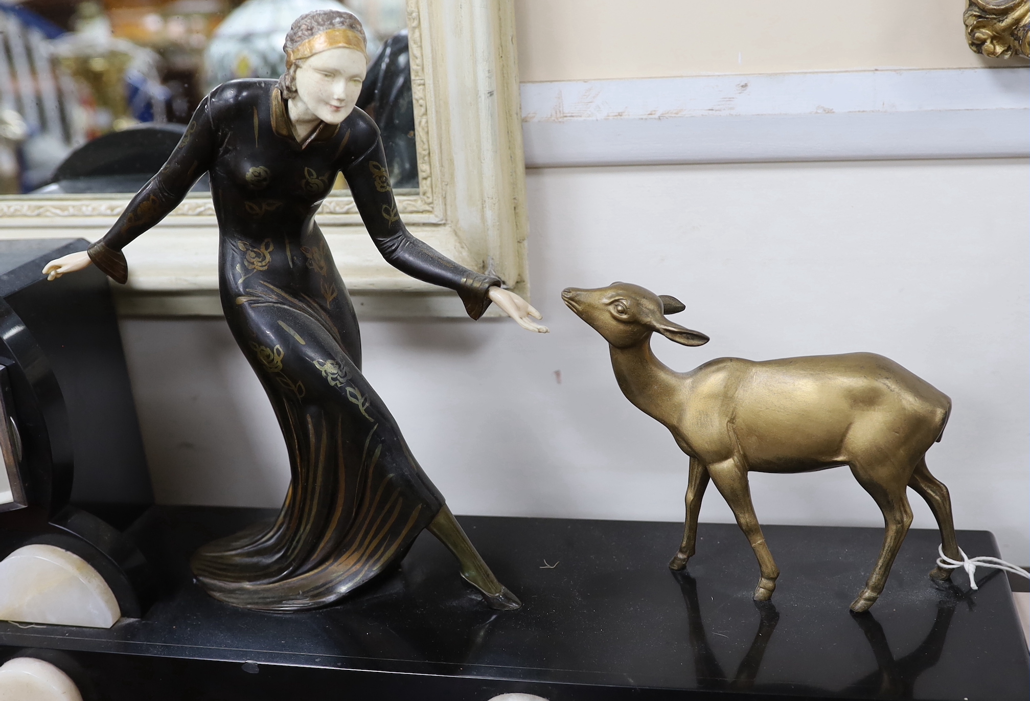 An Art Deco style bronze and ivorine figural mantel clock garniture, 64cm wide excluding garnitures